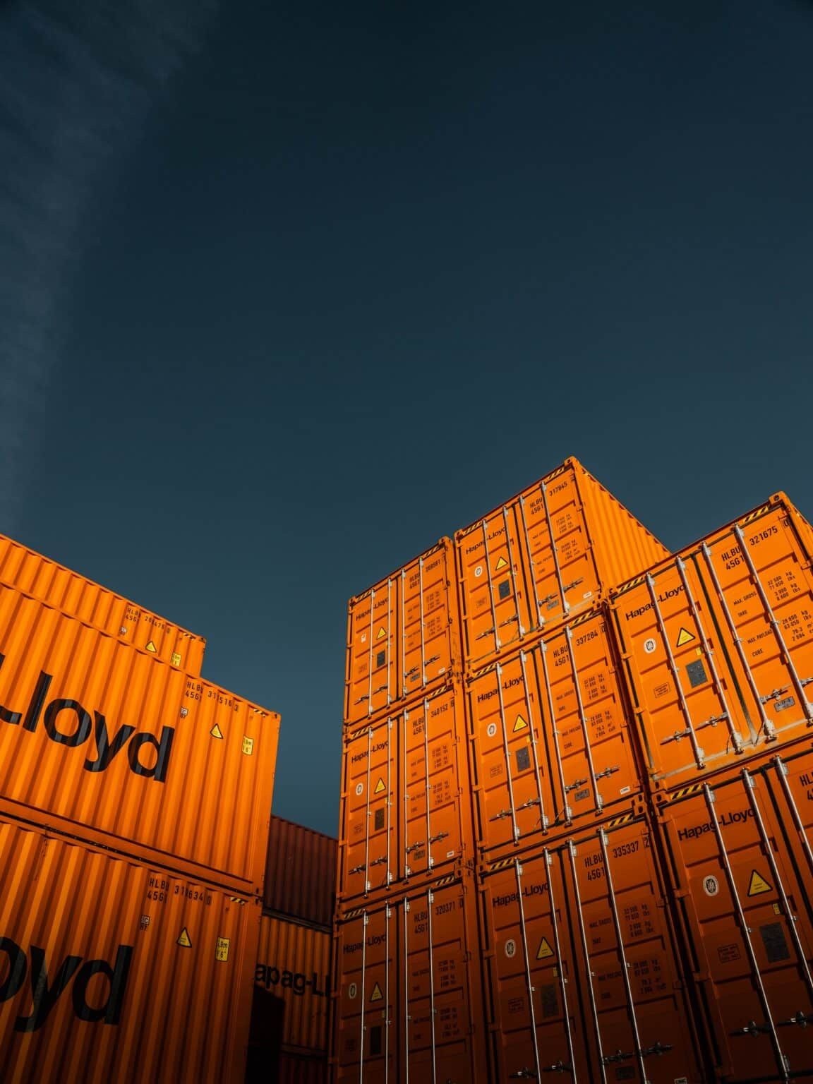 Orange shipping containers beneath a deep blue sky